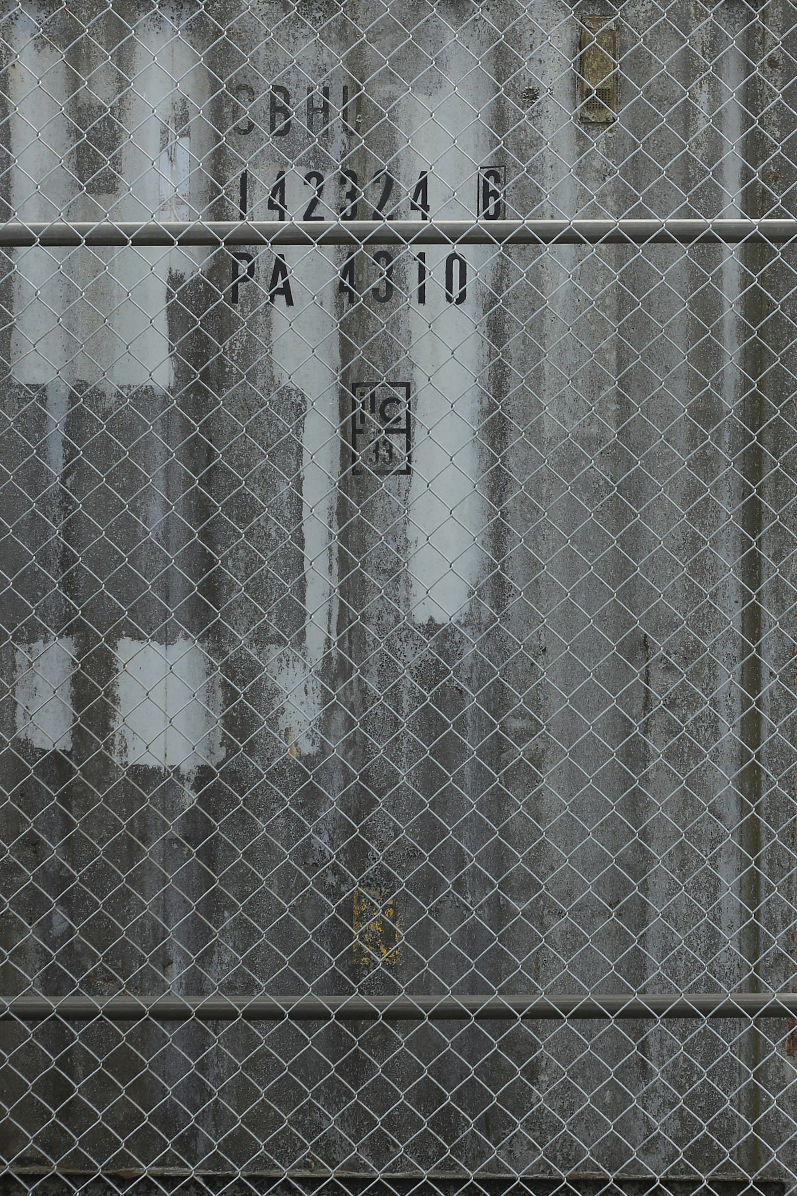 Chain-link fence in front of industrial shipping containers